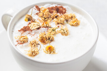 Chamomile moon milk with cinnamon in white cup. Ayurveda drink, chamomile latte tea.