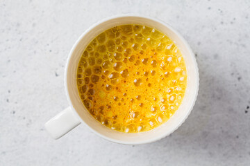 Golden turmeric moon milk in white cup. Ayurveda drink, healthy lifestyle, remedy for insomnia.