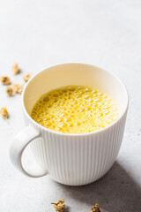 Golden turmeric chamomile moon milk in white cup. Ayurveda drink, healthy lifestyle, remedy for insomnia.