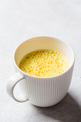 Golden turmeric moon milk in white cup. Ayurveda drink, healthy lifestyle, remedy for insomnia.