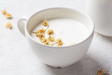 Chamomile moon milk in white cup. Ayurveda drink, chamomile latte tea.