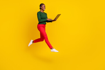 Fototapeta na wymiar Full length photo of shiny sweet lady dressed green shirt jumping high typing gadget empty space isolated yellow color background