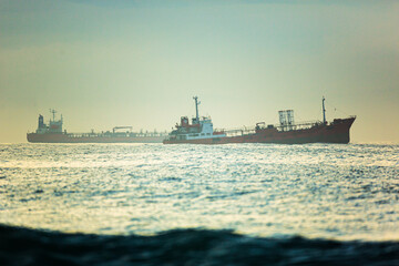 Two tanker ships stand on the roadstead of the bay at dawn