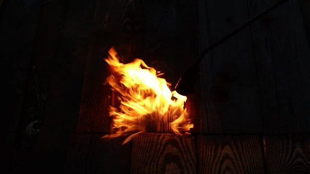 The gas burner burns with a blue flame. A bright golden fire burns the wood and it turns black. Video HD