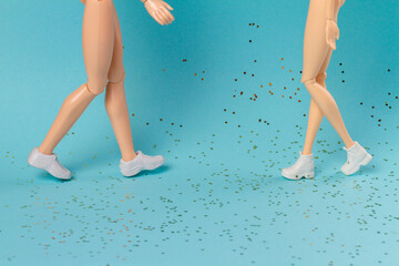 Walking toy doll mothers and daughter legs. Glitters on blue background.