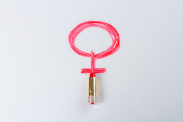 Red lipstic draw female symbol on white. Circle and cross.