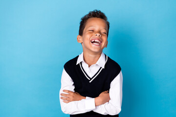Photo of excited funky small boy wear black waistcoat laughing arms crossed isolated blue color...
