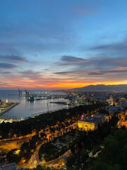 aerial view of an amazing sunset in Malaga harbor from Castillo de Gibralfaro, Andalusia, Spain....