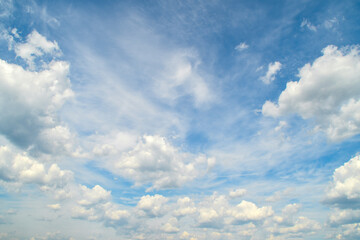 Naklejka na ściany i meble Background with high blue sky and white clouds. Summer sky with cumulus clouds.