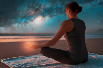 silhouette of a woman on the beach outdoors meditating at night with stars and milky way in the background	 - obrazy, fototapety, plakaty