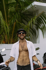 Young stylish man in sunglasses and panama hat and white shirt.