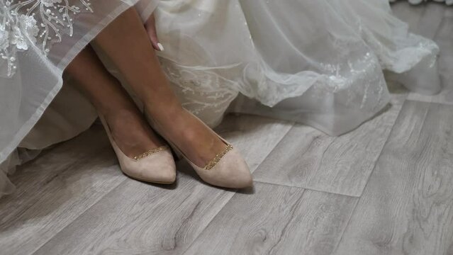 the bride put on her shoes and put on a dress that slightly covered the shoes