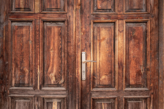 Old, rustic, classical, brown, wooden door with iron door handle. Door textures and background.
