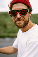 Young handsome man surfer in sunglasses and white t-shirt.