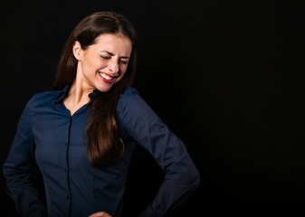 Fototapeta na wymiar Beautiful fun humor toothy laughing business woman with folded arms in blue shirt on black background with empty copy space for text. Closeup