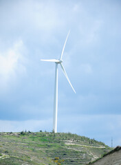 Fleet of power generators in motion. The blades of the wind farm rotate against the sky. The concept of extracting electricity from renewable sources. Wind turbine to generate electricity.