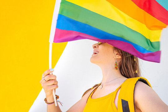Cheerful woman with LGBT flag looking away