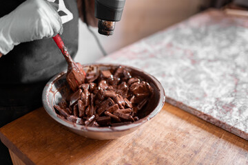 Anonymous worker heating chocolate with heat gun