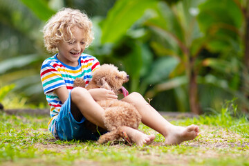 Kids play with puppy. Children and dog in garden.