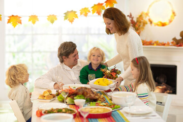 Family with kids at Thanksgiving dinner. Turkey.