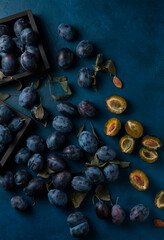 Delicious ripe black plums on table blue table