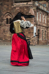 Strasbourg - France - 17 September 2022 - Portrait on back view of woman wearing a traditional medieval costume walking in the street - obrazy, fototapety, plakaty
