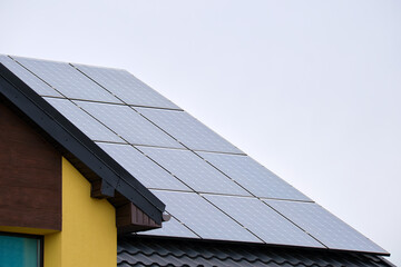 Private home roof covered with solar photovoltaic panels for generating of clean ecological electric energy in suburban rural town area. Concept of autonomous house