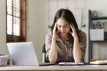 Depressed tired asian businesswoman, stressed at office workplace.