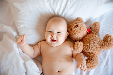 baby boy at home in the bedroom lying on a white sheet top view