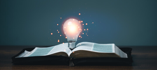 Light bulb glowing on the book, idea of ​​inspiration and wisdom from reading, innovation idea,...