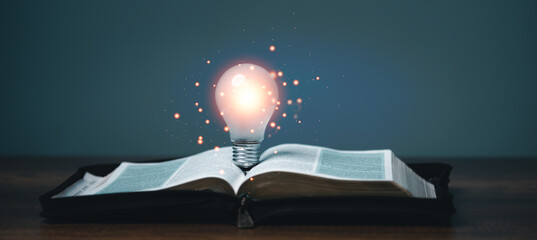 Light bulb glowing on the book, idea of ​​inspiration and wisdom from reading, innovation idea, Self learning or education knowledge and business studying concept.