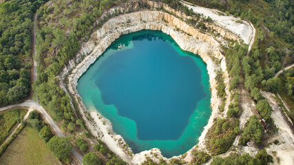 drone aerial photo of flooded Cartelle quarry in Spain, green lakes near granite mine, quarry