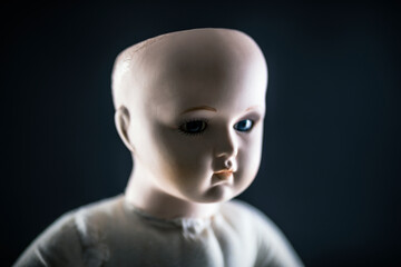 Creepy doll face on dark background