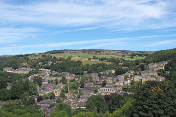 Fototapeta na wymiar view of hebden bridge showing streets and the town centre surrounded by pennine countryside in summer sunlight