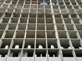 Construction of a multi-storey building made of concrete blocks and bricks.