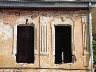 A crumbling old brick house. Empty windows.