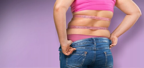 Overweight woman with a measure tape on belly