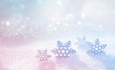 Beautiful composition for creative work, congratulations or postcards on winter theme with snowflakes in fluffy snow and sparkles in white, pink and blue tones.