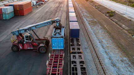 Aerial view crane loading container from container truck to container train, Cargo train with...