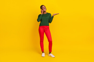 Full length photo of charming dreamy lady dressed green shirt communicating gadget empty space isolated yellow color background