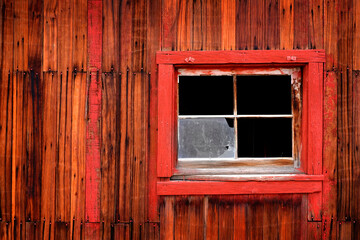 Obraz na płótnie Canvas Old Weathered Barn Wall with Red Paint Windows and Nails