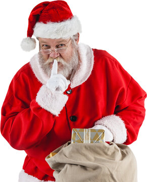 Image of santa claus with finger on lips holding christmas presents