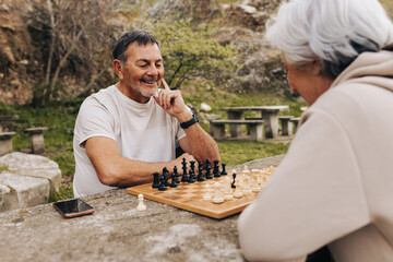 Smiling senior couple playing chess together