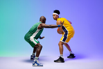 Naklejka premium Image of two diverse basketball players with basketball playing on purple to green background