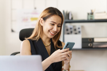 Attractive asian young woman using smartphone working office desk in office workplace.