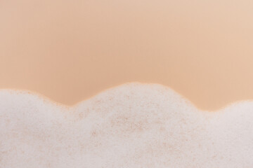 Cleanser foam texture. Soap, shampoo, detergenton on beige background.  Wash lather close up