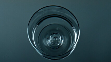 Water droplet falling cup top view. Pure liquid waving rippling in transparent