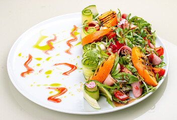 Fresh salad with ham and arugula, with grilled persimmon.