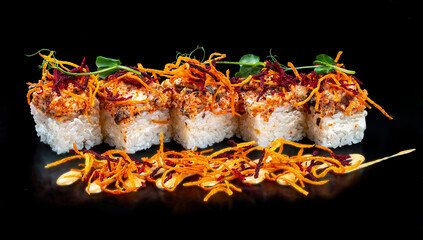 Sushi-Cake with Philadelphia cheese, tobiko caviar and eel. On a black background.