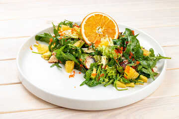 Juicy salad with arugula , orange and avocado. On a light background.
